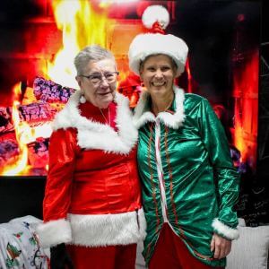 Linda Warren and Wendy Pobirk pose together after Linda passed the Queer Santa hat to Wendy.