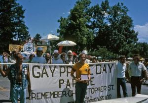 Community members stand with a banner in a parade at the first celebration of Denver Pride in 1974
