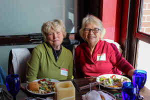 Kathleen Ryan (left), smiles alongside another West of 50 member